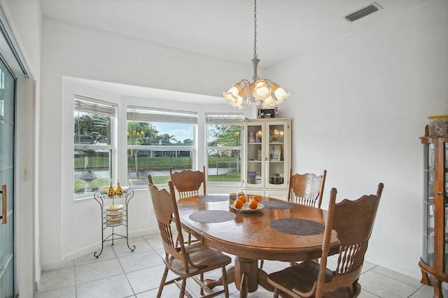 tiled dining area featuring a chandelier