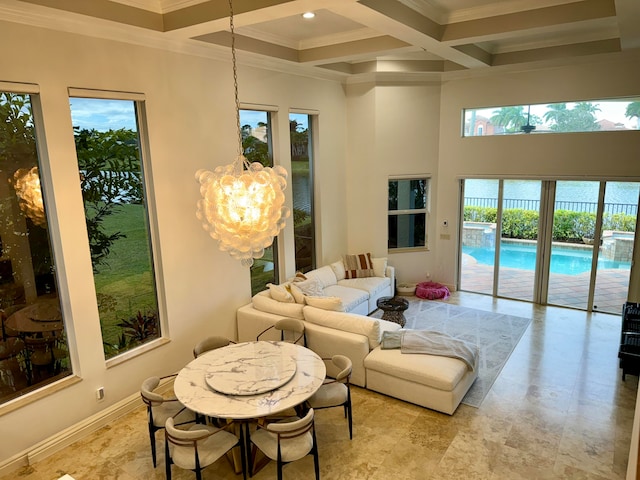 interior space featuring a notable chandelier, ornamental molding, coffered ceiling, and a healthy amount of sunlight