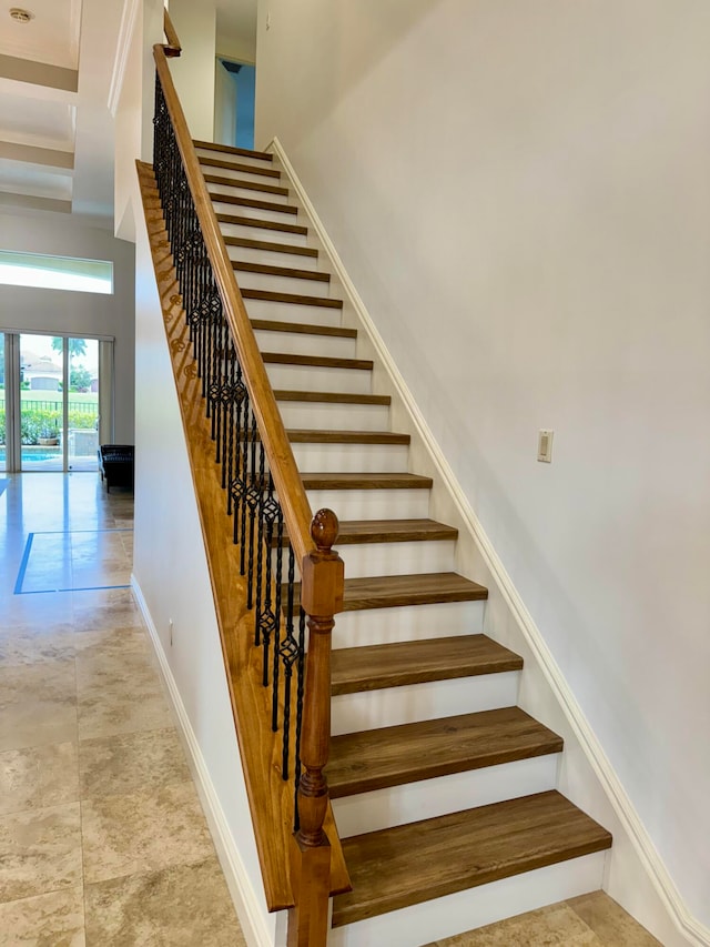 staircase featuring a high ceiling and light tile floors