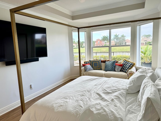 bedroom featuring crown molding, dark wood-type flooring, and a tray ceiling