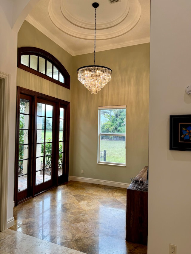 tiled entrance foyer featuring a chandelier and a tray ceiling