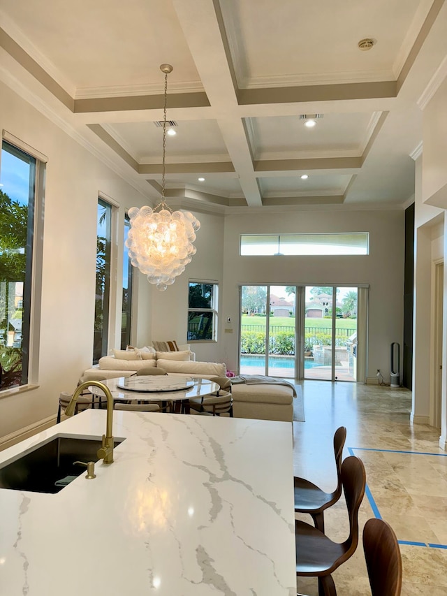 kitchen featuring an inviting chandelier, hanging light fixtures, light tile flooring, beamed ceiling, and coffered ceiling