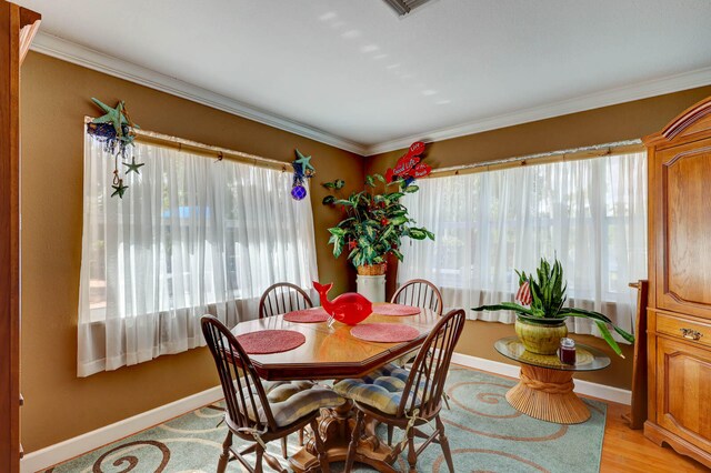 dining area featuring light hardwood / wood-style flooring and ornamental molding