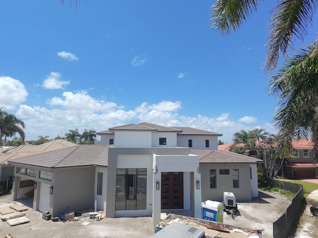 rear view of house featuring a patio area, stucco siding, and a tiled roof