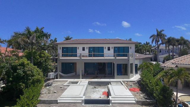 back of property featuring stucco siding, a patio area, and a balcony