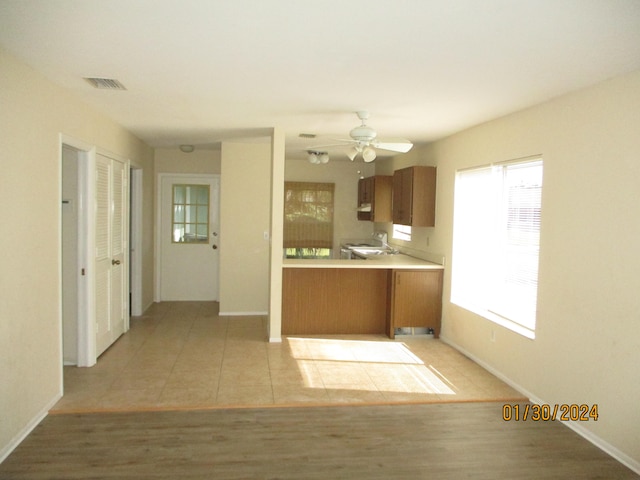 kitchen with light tile floors, sink, ceiling fan, and a wealth of natural light