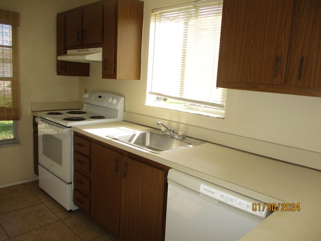 kitchen featuring wall chimney exhaust hood, white appliances, light tile flooring, and sink