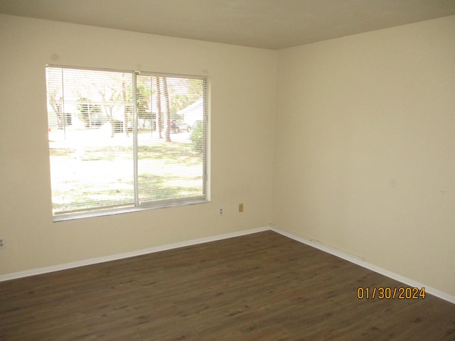 empty room with dark wood-type flooring and a wealth of natural light