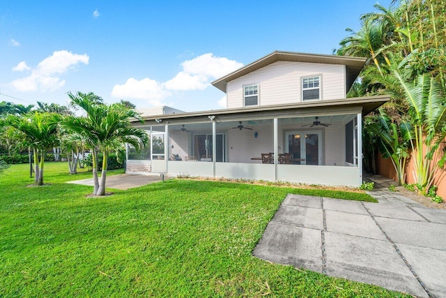 back of property featuring a yard, ceiling fan, a sunroom, and a patio area