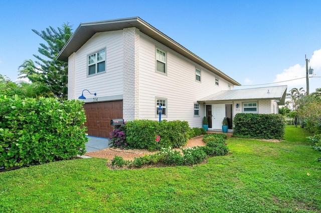 back of property with a garage and a lawn