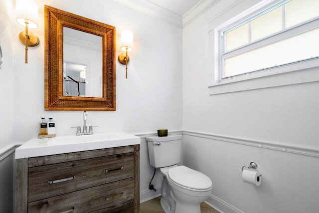 bathroom featuring toilet, crown molding, and vanity