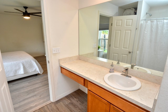 bathroom with hardwood / wood-style floors, large vanity, and ceiling fan