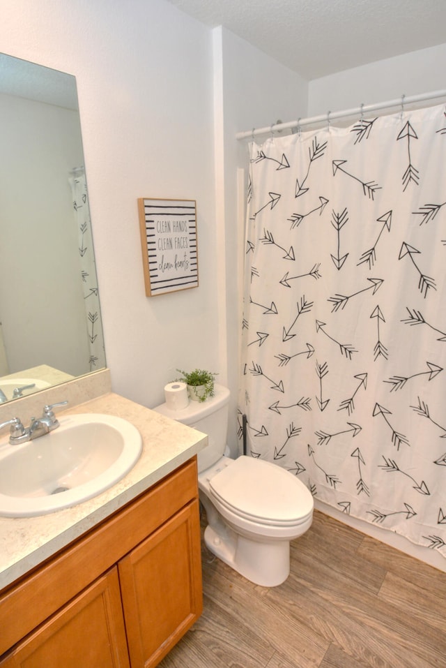 bathroom featuring hardwood / wood-style flooring, toilet, a textured ceiling, and vanity