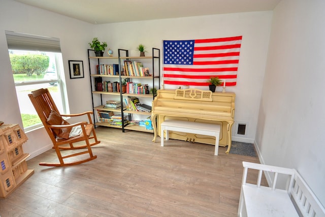 sitting room with plenty of natural light and light hardwood / wood-style flooring