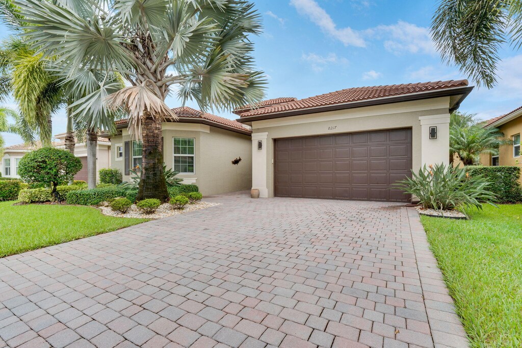 mediterranean / spanish home featuring a garage and a front yard