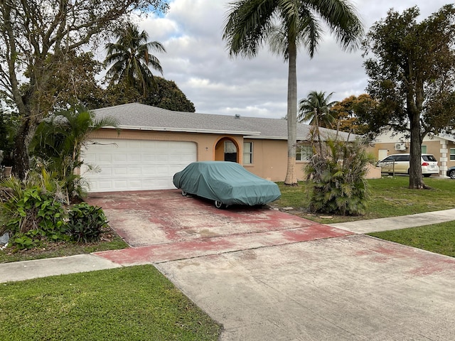 single story home with a front yard and a garage