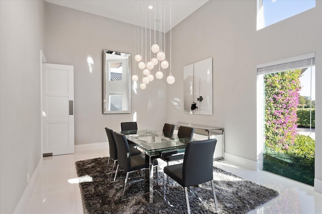 dining area featuring light tile floors and a towering ceiling