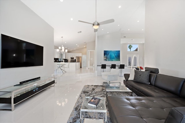 tiled living room featuring high vaulted ceiling and ceiling fan with notable chandelier