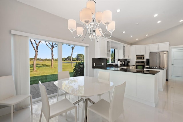 tiled dining room featuring high vaulted ceiling, an inviting chandelier, and sink