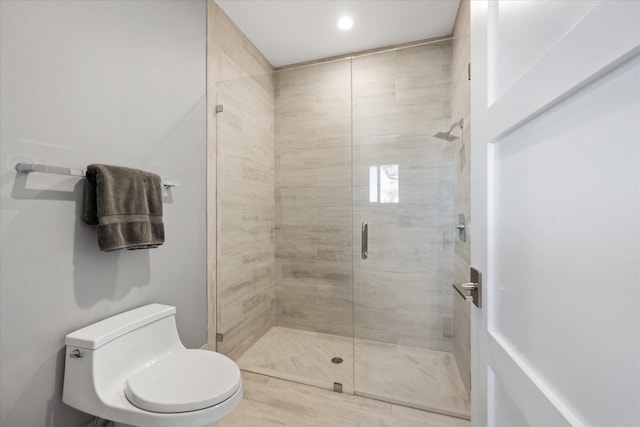 bathroom with an enclosed shower and toilet