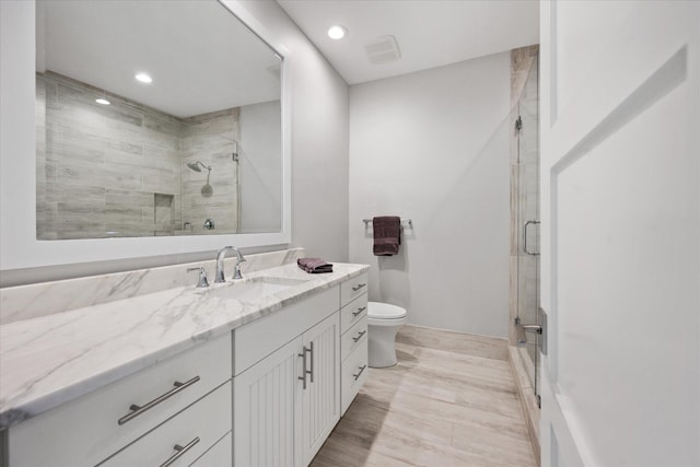 bathroom with vanity, tile flooring, a shower with door, and toilet