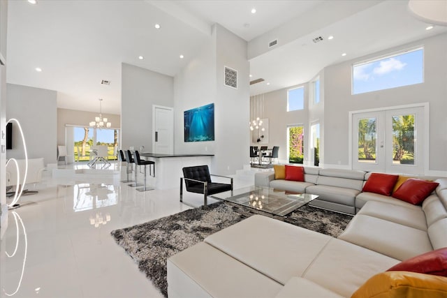 living room with french doors, tile floors, a notable chandelier, and a high ceiling