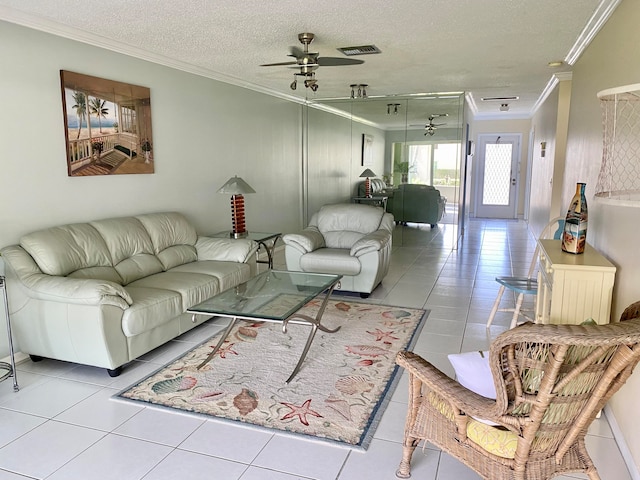 tiled living room featuring ceiling fan, a textured ceiling, and ornamental molding