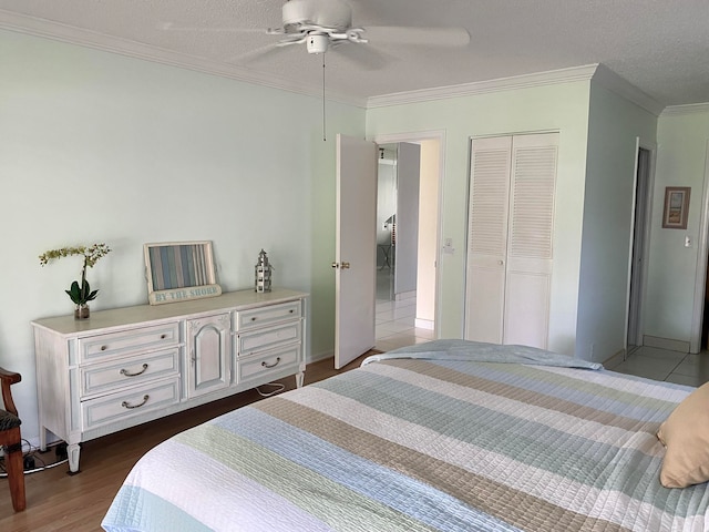 bedroom with ornamental molding, a textured ceiling, ceiling fan, dark wood-type flooring, and a closet