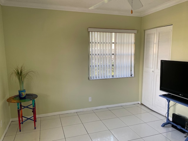 interior space featuring ceiling fan, light tile patterned flooring, and ornamental molding