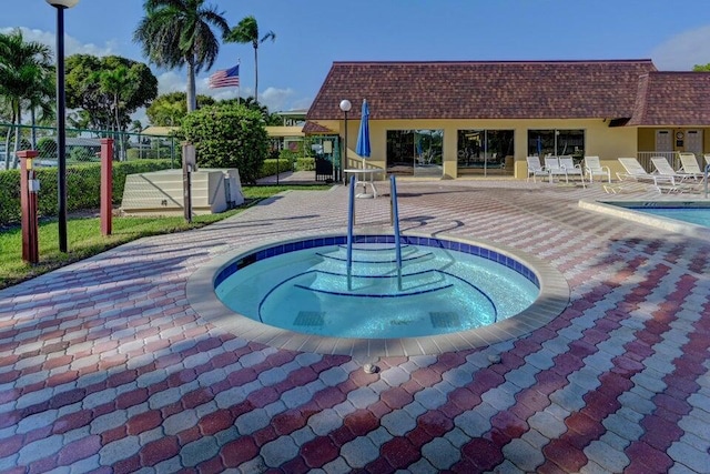 view of swimming pool featuring a patio area and a hot tub