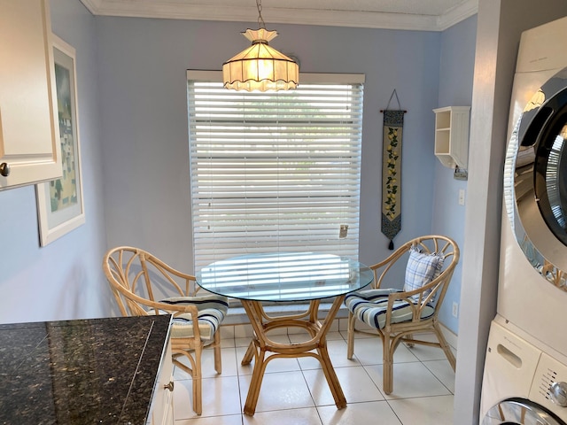 dining room featuring ornamental molding, stacked washer / dryer, and light tile patterned floors