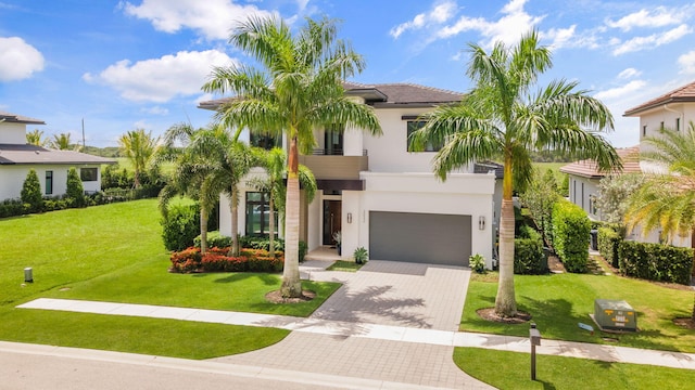 mediterranean / spanish home featuring a garage and a front lawn