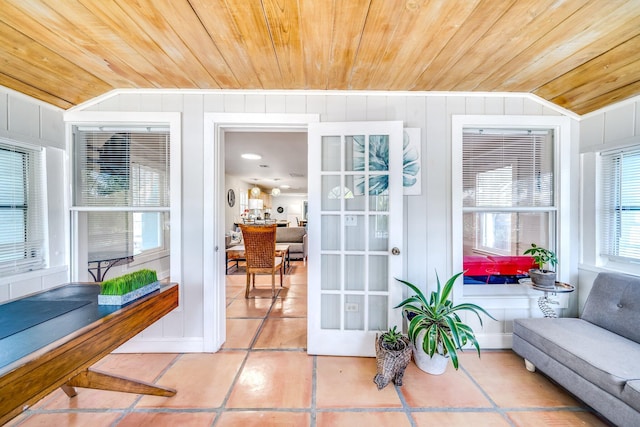 sunroom / solarium featuring lofted ceiling and wood ceiling