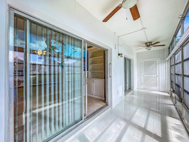 unfurnished sunroom featuring ceiling fan