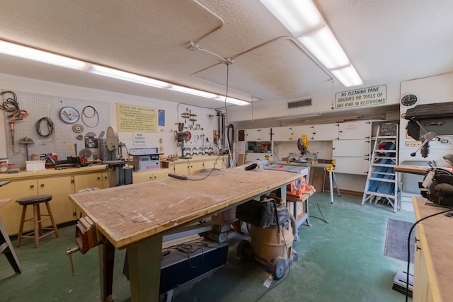 interior space with a textured ceiling and a workshop area