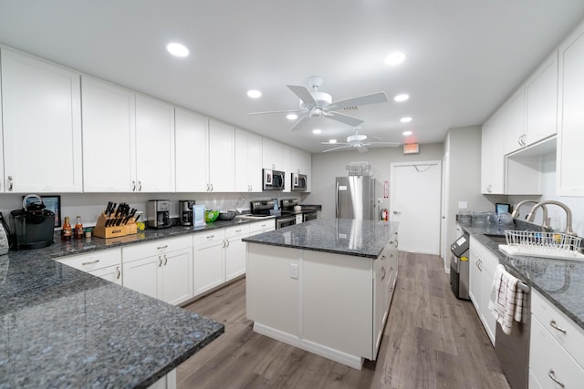 kitchen with a center island, ceiling fan, appliances with stainless steel finishes, and wood-type flooring