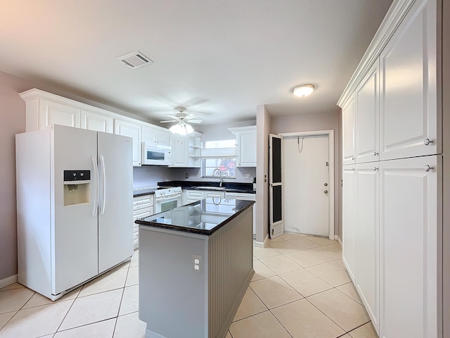 kitchen featuring white cabinetry, ceiling fan, white appliances, light tile floors, and a center island