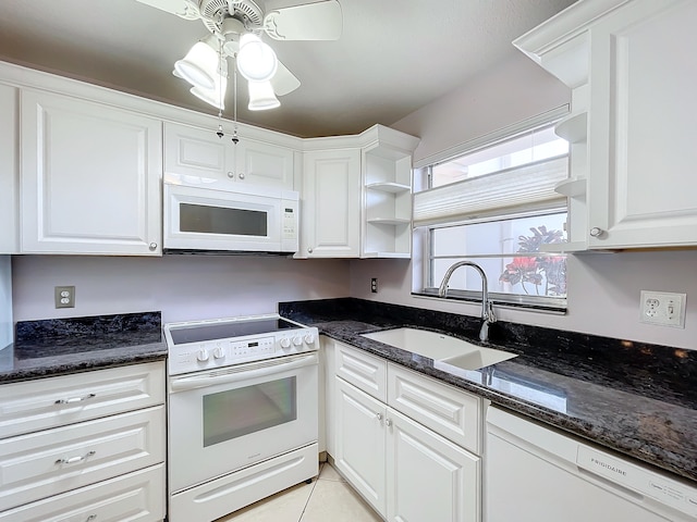 kitchen with white appliances, sink, ceiling fan, dark stone countertops, and white cabinetry