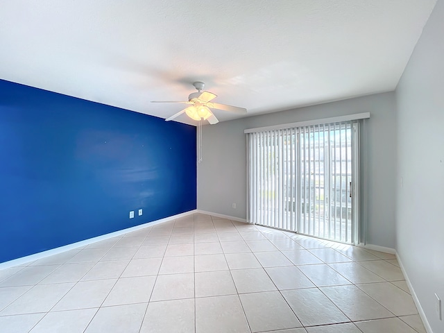 tiled spare room with ceiling fan