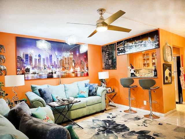 tiled living room with a textured ceiling and ceiling fan with notable chandelier