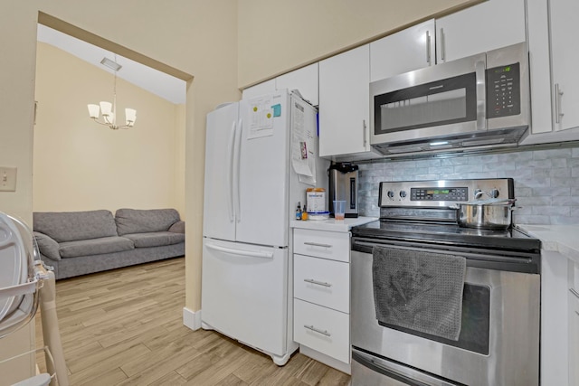 kitchen featuring light hardwood / wood-style flooring, stainless steel appliances, decorative light fixtures, decorative backsplash, and lofted ceiling