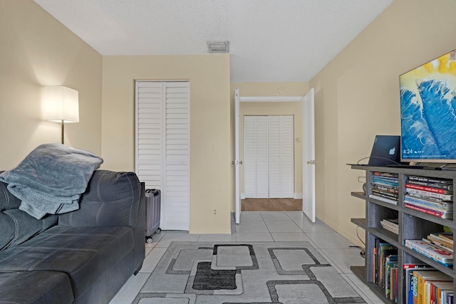 living room featuring light wood-type flooring and a textured ceiling