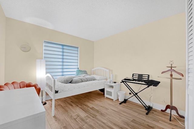 bedroom featuring light hardwood / wood-style floors and a textured ceiling