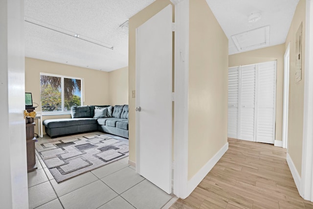 hall with light hardwood / wood-style flooring and a textured ceiling