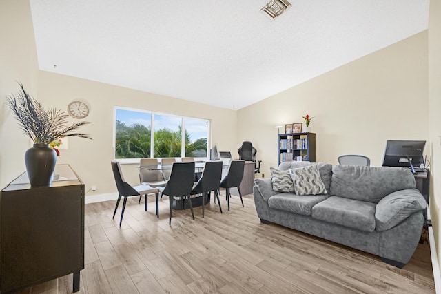 living room featuring hardwood / wood-style flooring and vaulted ceiling