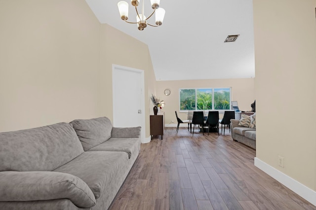 living room featuring wood-type flooring, a chandelier, and high vaulted ceiling