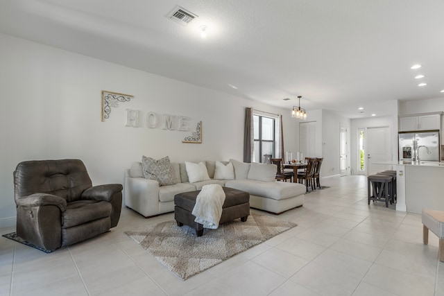 tiled living room with an inviting chandelier