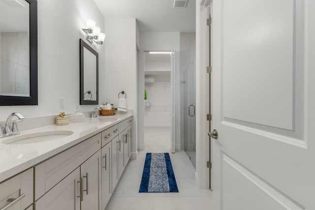 bathroom with tile flooring, dual vanity, and an enclosed shower