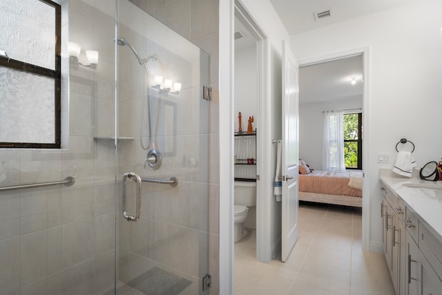 bathroom with toilet, tile flooring, walk in shower, and vanity