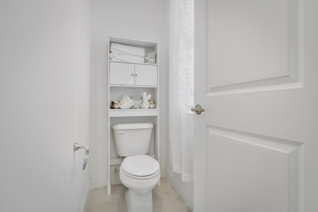 bathroom with toilet and tile floors